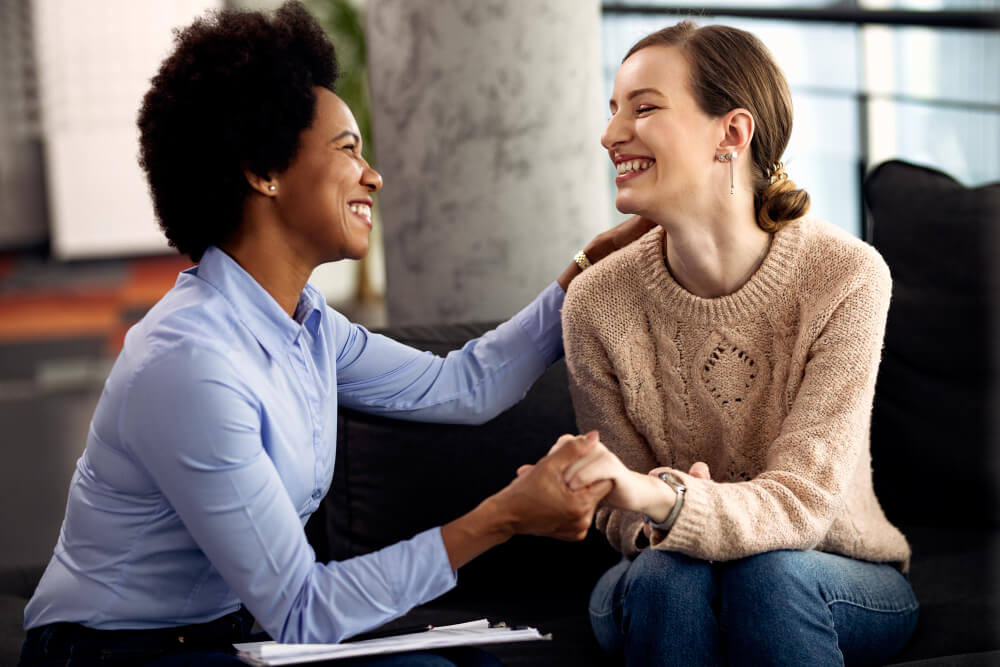 happy female workers holding hands